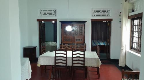 a dining room with a white table and chairs at Rajavilla in Haputale