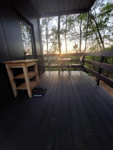 a porch of a cabin with a table and a bench at Stüble Kabinok in Somogyhárságy