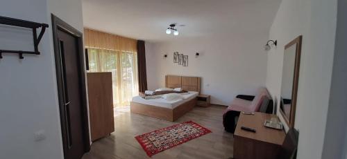 ein Schlafzimmer mit einem Bett und ein Wohnzimmer in der Unterkunft Casa Maria Moieciu de Sus in Moieciu de Sus