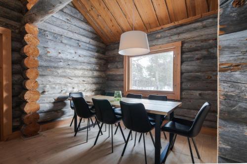 a dining room with a table and chairs in a log cabin at Kelokurki - The Luxury Lodge Where Serenity Meets the Northern Lights in Levi