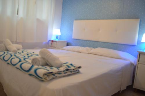 um quarto com uma cama branca e toalhas em Casa en Mirador del Codolar em Tossa de Mar