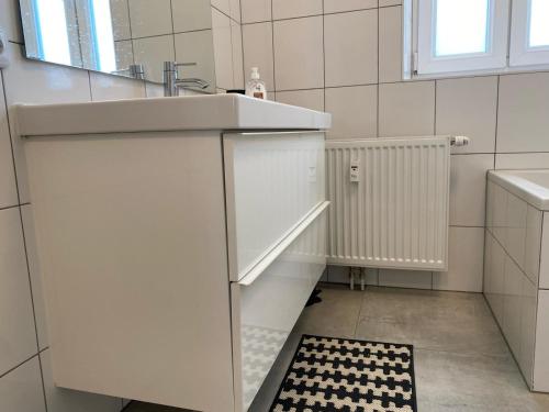 a white bathroom with a sink and a mirror at Altbau mit Flair in Klagenfurt