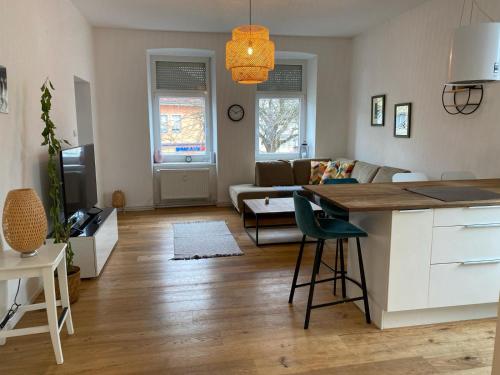 eine Küche und ein Wohnzimmer mit einem Sofa und einem Tisch in der Unterkunft Altbau mit Flair in Klagenfurt am Wörthersee