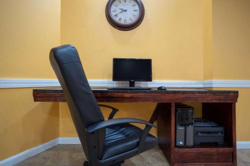 a chair in front of a desk with a computer at Super 8 by Wyndham Harrison OH in Harrison