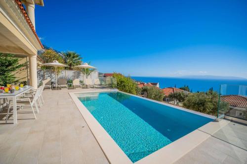 a swimming pool in a villa with a view of the ocean at Villa Andriana in Vlachata