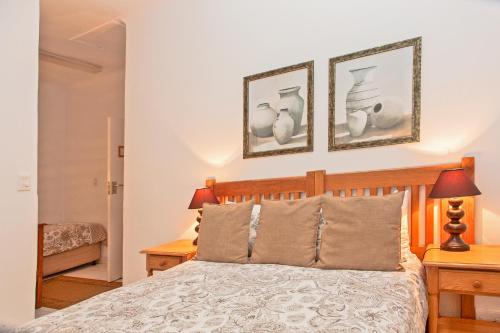 a bedroom with a bed and two pictures on the wall at Rivendell Bed and Breakfast in Hillcrest