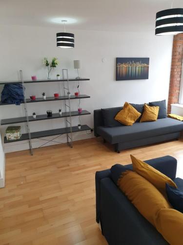 salon z 2 niebieskimi kanapami i drewnianą podłogą w obiekcie Fab Manchester City new one bed apartment w Manchesterze