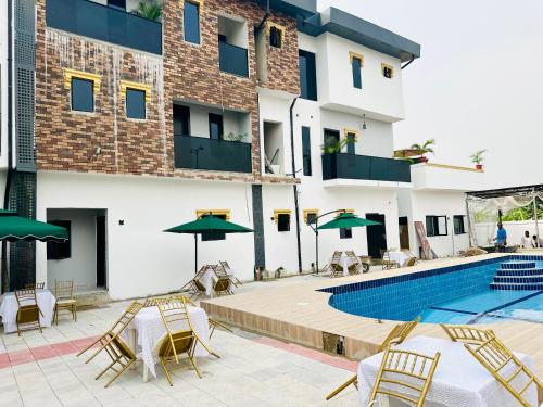 a hotel with a swimming pool with chairs and umbrellas at Valentino Swiss Hotel and Apartment in Port Harcourt