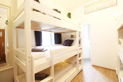 a white bunk bed in a room at Hotel Ulm Zentrum - Komplettes Zimmer, Hochbett, Android TV & eigenem Bad - perfekt für Familien & Gruppen in Ulm