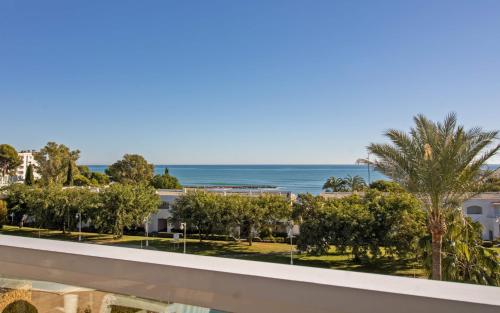 a view of the beach from the balcony of a resort at JARDINES DEL PUERTO Primera línea de playa ALBERT VILLAS in Alcossebre
