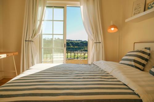 a bedroom with a bed and a large window at NEW! Quinta do Lago Golfside Retreat in Quinta do Lago