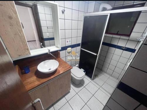 a bathroom with a toilet and a sink and a shower at Departamento a 20 metros do mar. in Florianópolis