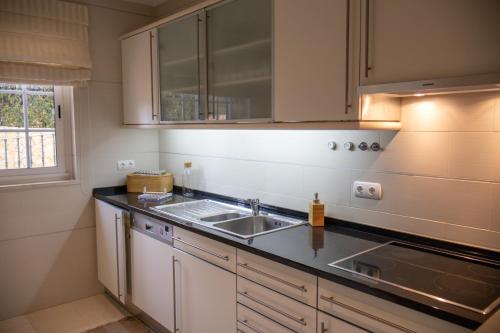 una cucina con un lavello e un piano di lavoro di Quinta do Lago Golfside Retreat a Quinta do Lago