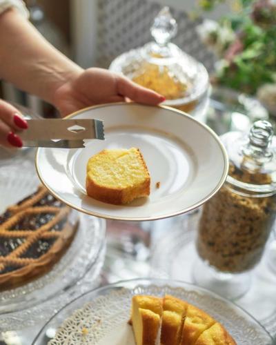 a person holding a plate with a piece of bread at Luxury Liberty House in Alghero