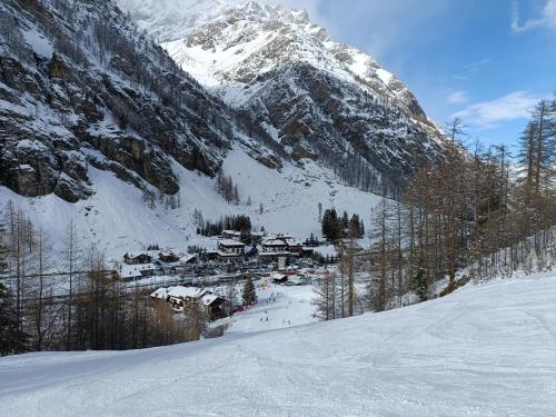 a small village in the snow in front of a mountain at Appartamenti Lucianaz in Rhêmes-Notre-Dame