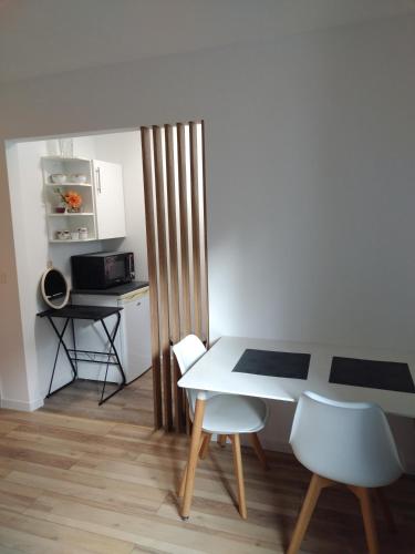 cocina con mesa, sillas y microondas en Studio indépendant location courte durée à proximité de Lycée International en Saint-Germain-en-Laye