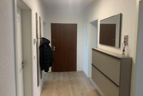 um corredor com uma porta e um corredor com um espelho em Private Apartment em Hanôver