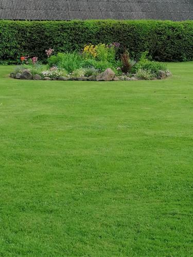 a yard with green grass and a garden with flowers at Villa River Rose in Jõesuu