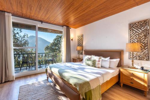 a bedroom with a bed and a large window at SaffronStays Naiintara in Nainital
