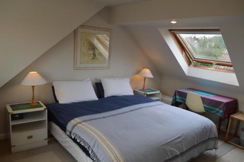 1 dormitorio con 1 cama, 2 mesas y una ventana en Wimbledon Views, en Londres