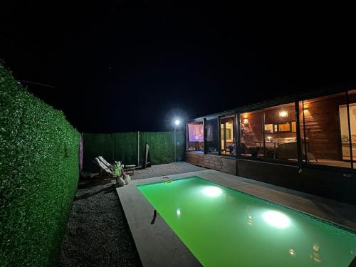 a swimming pool in front of a building at night at Tiny House Bungalow - Pool, Jacuzzi, Winter Garden in İzmir