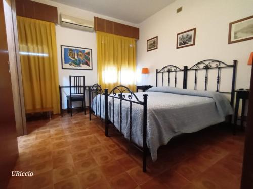 a bedroom with two beds in a room with yellow curtains at Casa Riccio in Palermo