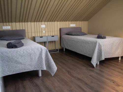 2 Betten in einem Zimmer mit Holzböden in der Unterkunft good mood guesthouse in Otepää