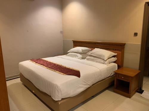 - une chambre dotée d'un grand lit avec des draps et des oreillers blancs dans l'établissement ENHAII HOTEL, à Bandung