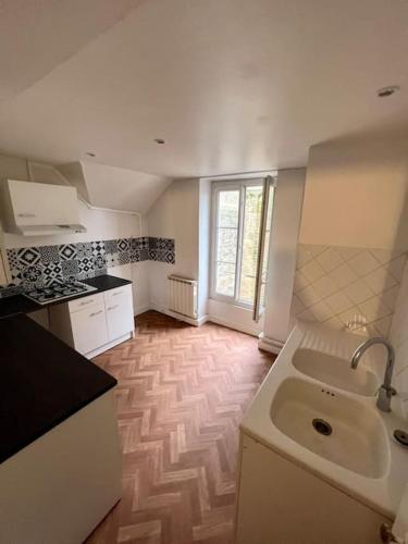 uma cozinha com um lavatório e uma bancada em Tea Time em Douvres-la-Délivrande