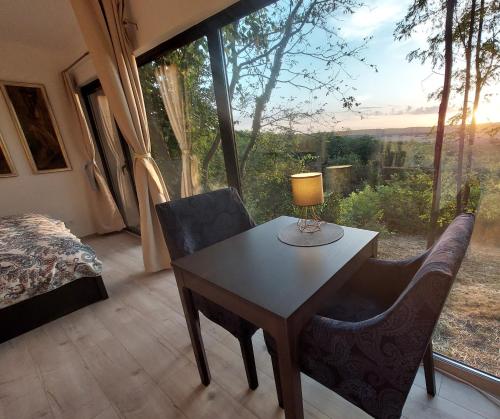 een kamer met een tafel en stoelen en een bed bij Stüble Kabinok in Somogyhárságy