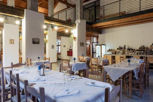 a dining room with tables and chairs with white tablecloths at ALLE ANTICHE MINIERE - CASA VACANZE in Zenich