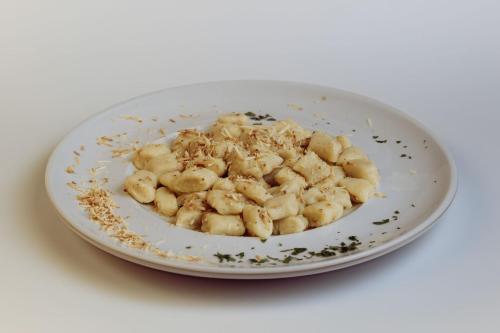a white bowl filled with food on a white plate at ALLE ANTICHE MINIERE - CASA VACANZE in Zenich