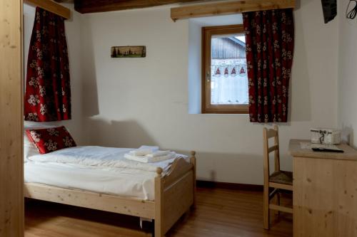 a small bedroom with a bed and a window at ALLE ANTICHE MINIERE - CASA VACANZE in Zenich