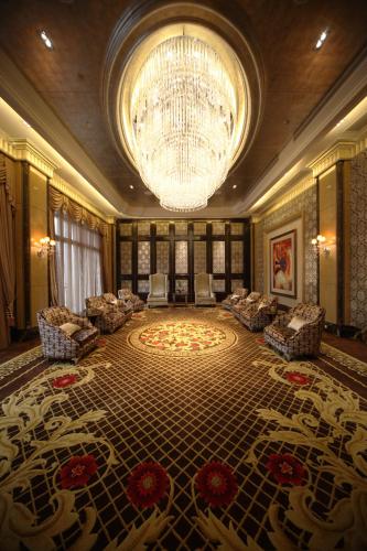 a large lobby with a chandelier and a large rug at Chateau Star River Pudong Shanghai in Shanghai