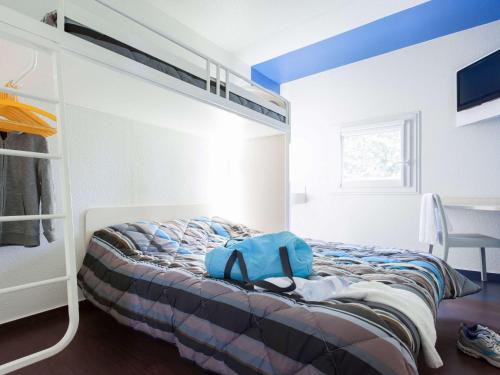 Un dormitorio con una cama con una mochila azul. en Hotel F1 Vesoul - En cours de rénovation, en Vesoul