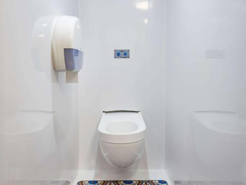 een witte badkamer met een toilet en een telefoon bij Hotel F1 Vesoul - En cours de rénovation in Vesoul