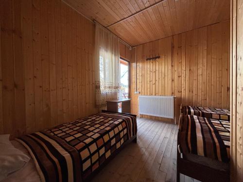 Cette chambre comprend 2 lits et une fenêtre. dans l'établissement Family Hostel Nika, à Kazbegi