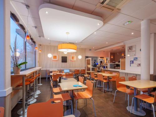 a restaurant with tables and chairs and a counter at ibis budget Saint-Quentin Centre Gare in Saint-Quentin