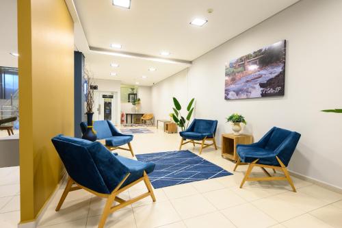 a waiting room with blue chairs and a blue rug at UniHotel Salto in Salto