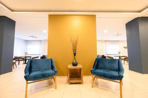 a waiting room with two blue chairs and a vase at UniHotel Salto in Salto