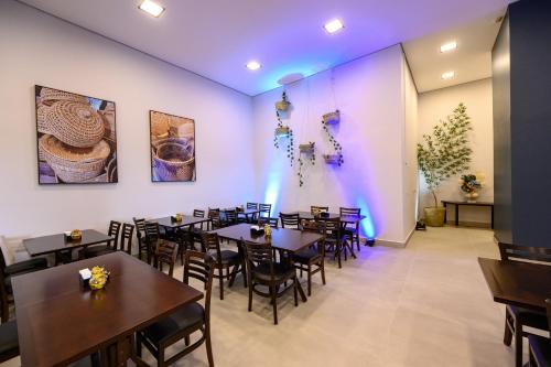 a dining room with tables and chairs and purple lighting at UniHotel Salto in Salto