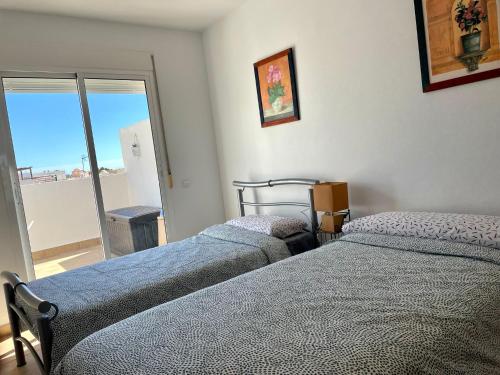 2 Betten in einem Zimmer mit Fenster in der Unterkunft La terraza de Jimena in Carboneras