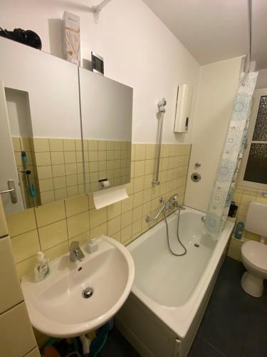 a bathroom with a sink and a tub and a toilet at Wiesbaden Mainz kostheim Bitte nur für männliche Only Men Gäste in Wiesbaden