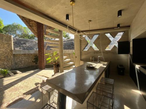 a kitchen with a sink and a counter with chairs at Happiness Kulambo Villa El Nido in El Nido