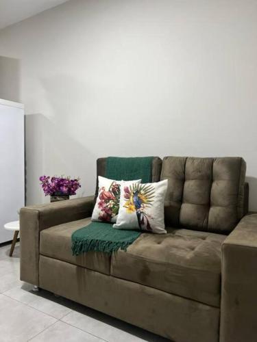 um sofá castanho com duas almofadas na sala de estar em Corredor turístico de Foz! em Foz do Iguaçu