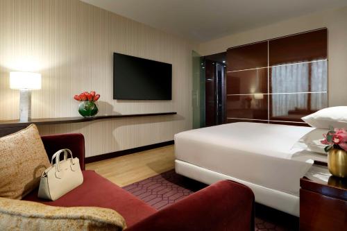 a hotel room with a bed and a tv at Hyatt Regency Barcelona Tower in Hospitalet de Llobregat