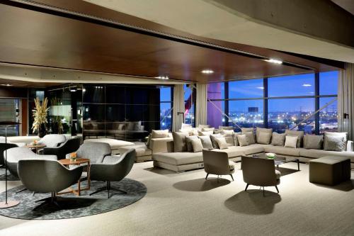 a living room with white furniture and a large window at Hyatt Regency Barcelona Tower in Hospitalet de Llobregat
