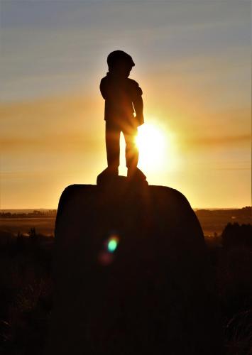 a child standing on top of a rock at sunset at Sonvanger Selfcatering in Orania