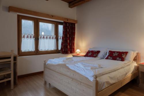 a bedroom with a large white bed in front of a window at ALLE ANTICHE MINIERE - CASA VACANZE in Zenich