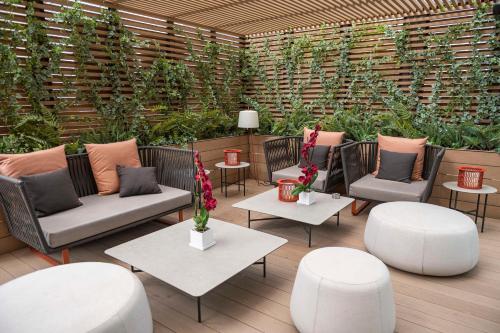 a patio with chairs and tables and plants at Hyatt Regency Barcelona Tower in Hospitalet de Llobregat